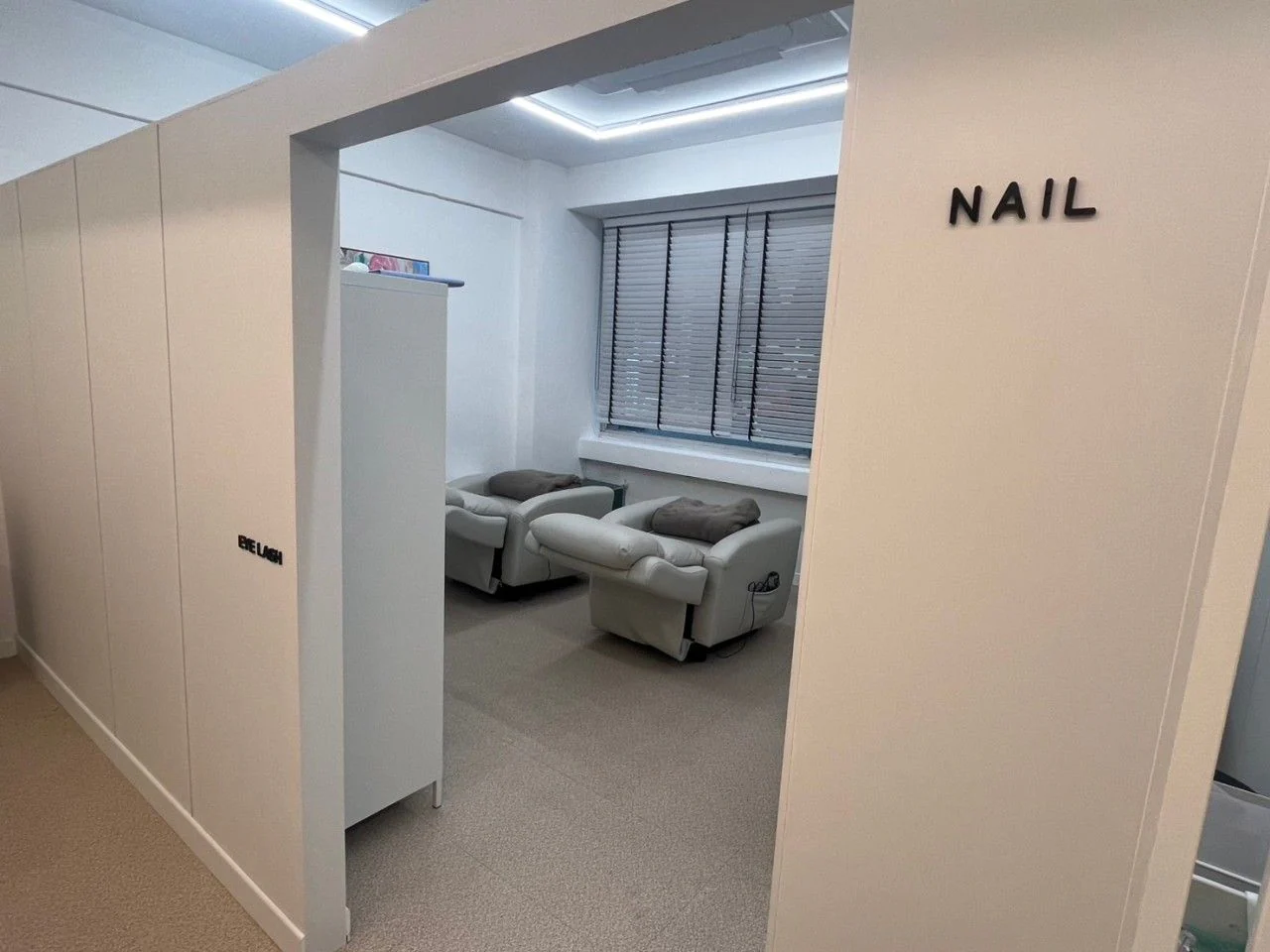 掛有 EYE LASH・NAIL 標示的療程室入口與躺椅